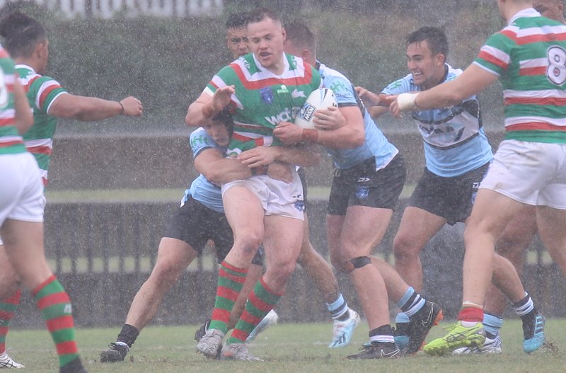 Luke Bain Rabbitoh's Lock get wrapped up by the Sharks Defense in the massive downpour at Redfern Oval on Sunday in the NSWRL Jersey Flegg Cup Season opener (Photo : Steve Montgomery)