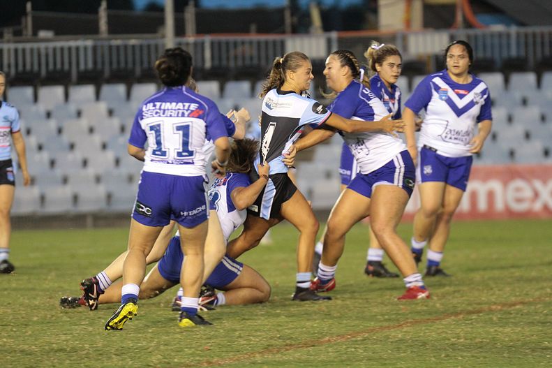 Sharks Ella Barker tries to find a way through the Bulldogs in the rain at Shark Park (Photo : Steve Montgomery)