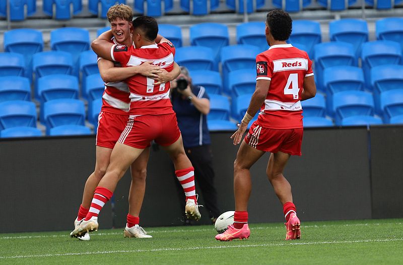 NRL National Schoolboys Cup final at CBUS Stadium between Palm Beach Currumbin and Patrician Blacktown Brothers. The Red Army and Palm Beach Currumbin 's Beau Hartmann scores the winning try and celebrates with team mates. (Photo : Steve Montgomery)