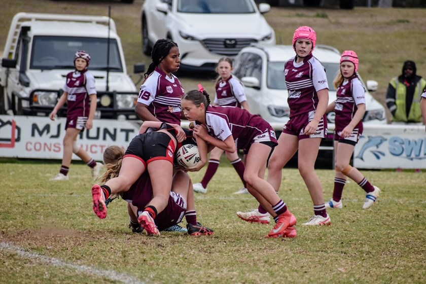 Dalby Devils Samara Mittelstadt (left), club captains Mia Deem and Cooper Collins man the bake sale to raise money for McGrath Foundation breast cancer nurses in Dalby. (Photo : QRL)